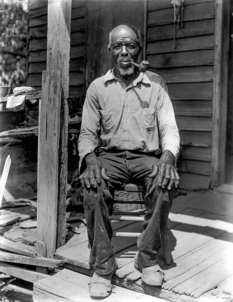 Cudjo Lewis seated on the porch of his home in Africatown, Alabama, photographed in 1927